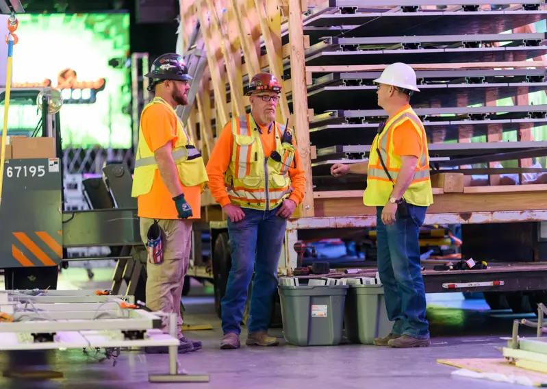 Workers chat near a semi load of panels to be installed on the Fremont Street Experience digital canopy.